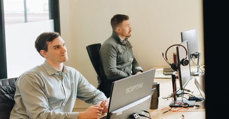 Pioneer employees sitting at a desk, working on their laptops