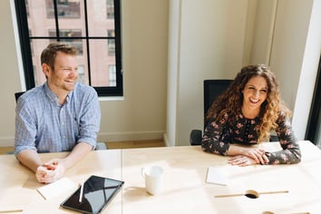 A man and a woman sitting at a conference table.