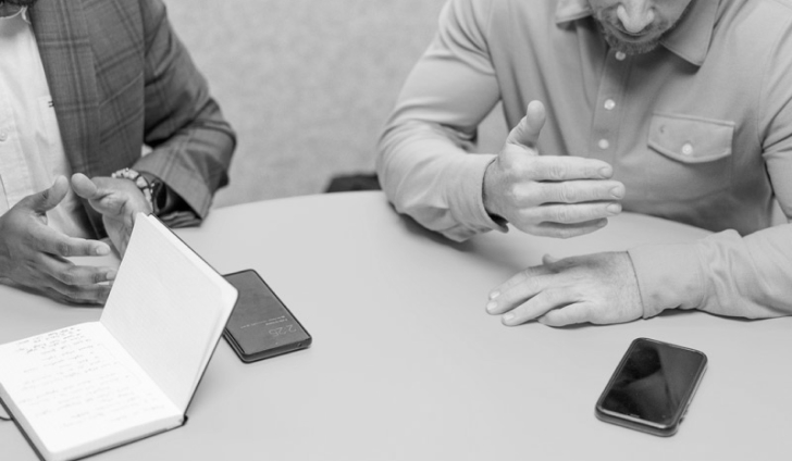 Two men sitting at a round table.