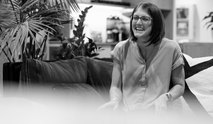 A woman sitting on a couch and laughing.