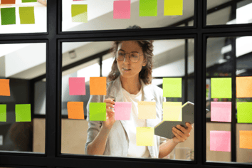 Woman placing sticky notes on window