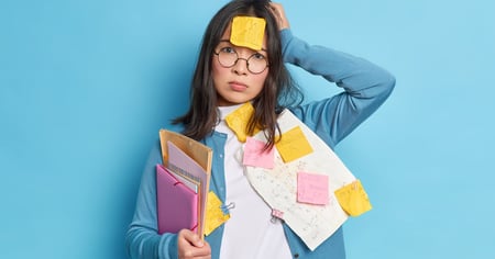 Woman disheveled with sticky notes and papers